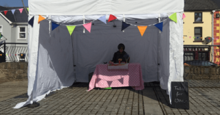 person listening to table for one audio in marquee