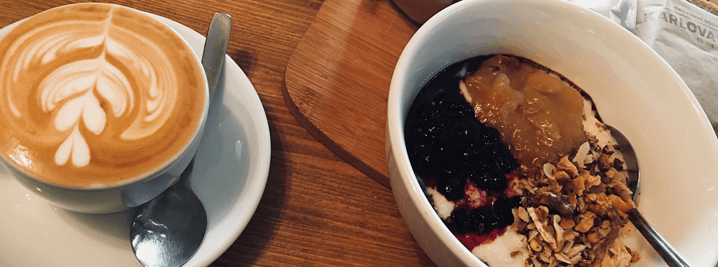 a bowl of porridge and a cappucino