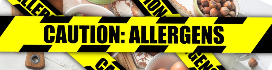 Warning tape that reads "Caution: Allergens" in front of a selection of foods that might be allergens