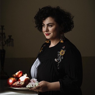 Portrait of Saghhar Setareh holding a plate of pomegranates