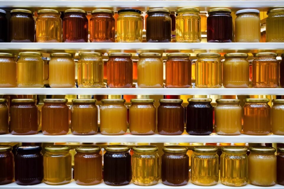 Unlabelled jars of honey on shelves