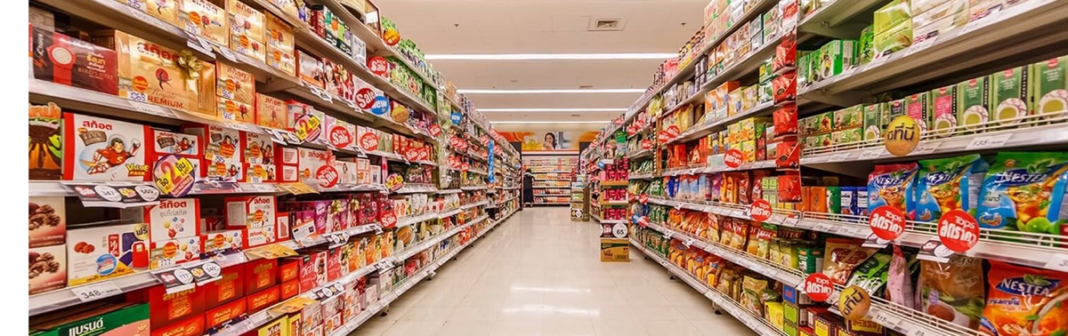 Supermarket shelves crammed with colourful packages converging on a vanishing point in the far distance.